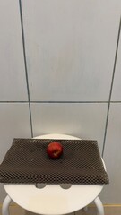 Single Red Nectarine on Textured Mat on Stool