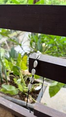 Handmade White Seashell Bracelet Hanging on Balcony Railing