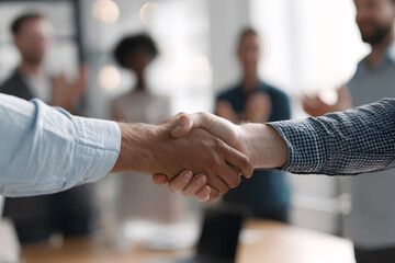 Business partners shake hands to celebrate a successful deal in a bright office setting