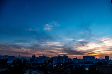 Fototapeta premium Evening scene with lit up and silhouetted buildings against a colourful evening sky at Pune India.