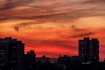 Fototapeta premium Evening scene with lit up and silhouetted buildings against a colourful evening sky at Pune India.