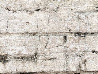 Old brick wall with significant weathering and a textured surface.