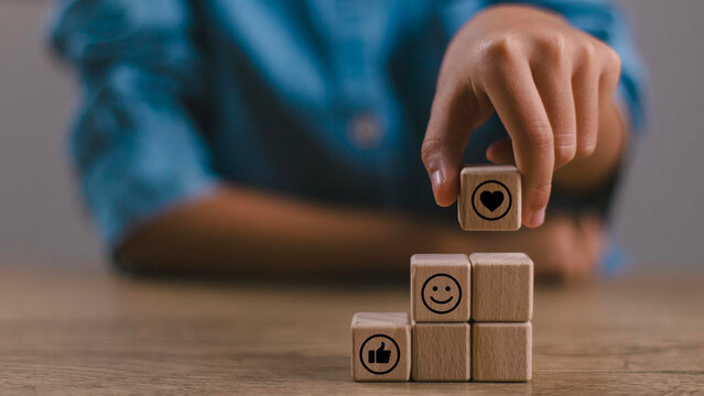 Social media engagement, Digital marketing concept. Stacking the wooden cube blocks with emoticons, creating social media platforms to build relationships and drive sales. Sharing customer experience.