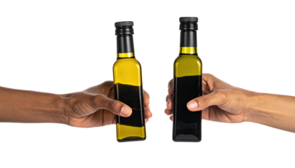 Hands hold glass bottles filled with oil against black