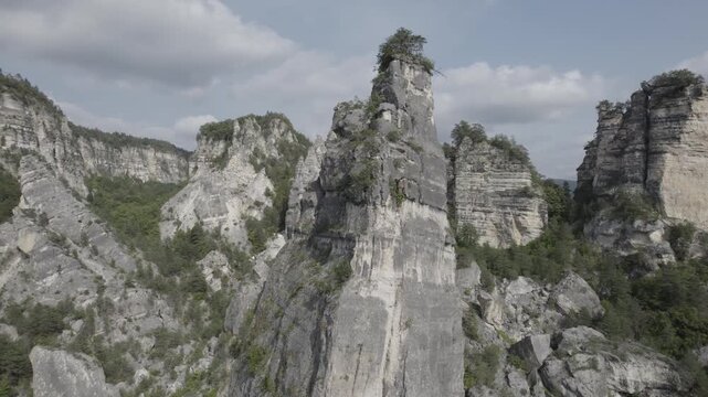 Aerial drone shot gliding past the Sairme Pillars in Lechkhumi, Georgia, revealing towering rock formations surrounded by green hills and untouched Caucasus nature. High-quality 4K footage.