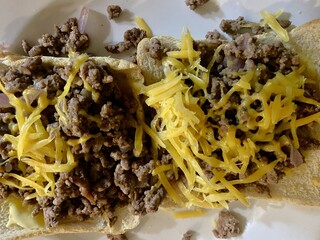 Fried beef mince with grated cheddar cheese on buttered white bread toast