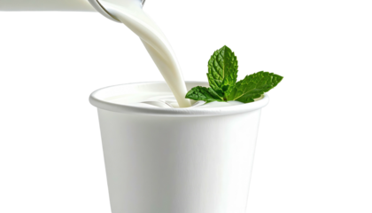 Milk pouring into a paper cup, mint garnish, dark background