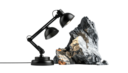 A black lamp illuminating a craggy, gray rock formation against black