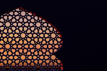 A close-up of a beautifully intricate geometric design silhouetted against a colorful sunset sky, showcasing cultural artistry and architectural detail.