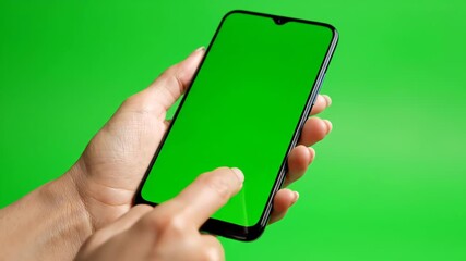 Hand holding smartphone with green screen on green background - Powered by Adobe