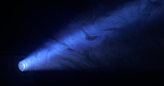 Blue Spotlight Beam Through Haze. Projector light ray piercing atmospheric smoke, building dramatic volumetric glow against dark background.