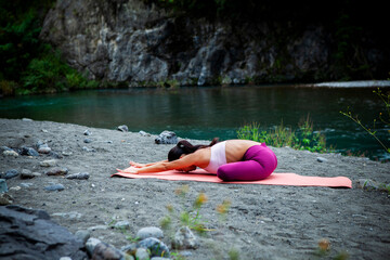 Japanese woman practicing gentle yoga stretching outdoors