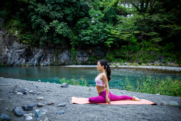Woman Stretching Hips in Low Lunge Yoga Pose on Riverside Yoga Mat