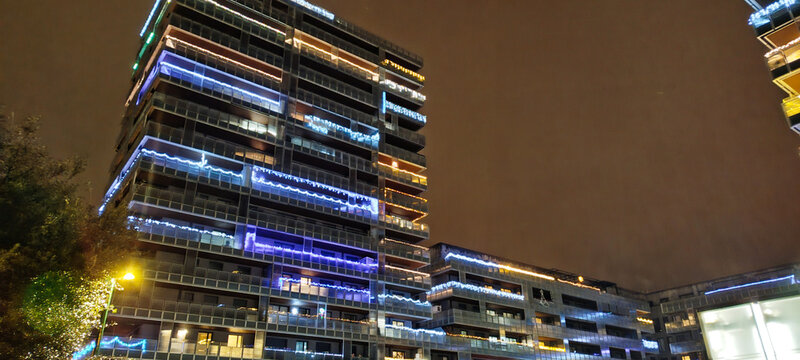 Edificio de oficinas moderno con iluminaci&oacute;n navide&ntilde;a led de colores en las fachadas durante la noche urbana 