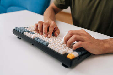 Closeup of unrecognizable man hands typing on mechanical keyboard featuring finger splint, representing focus on productivity, health and medical condition, injury at desk.