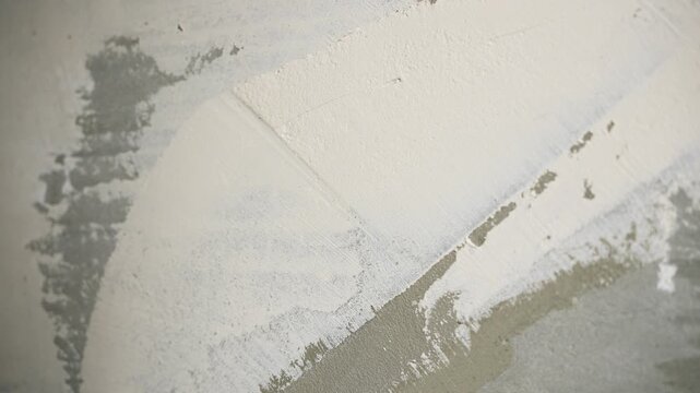 Interior Wall Being Smoothed By Skilled Worker, Closeup Of Hand Applying Plaster To Interior Surface
