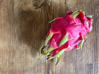 Fresh pink dragon fruit on rustic wood table background