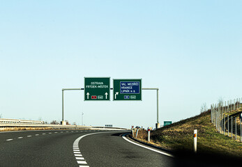 Empty highway with road signs stretching through a rural landscape. Transportation and travel infrastructure concept.
