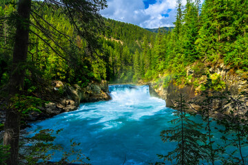 Fototapeta premium Overlander falls crashing into turquoise water in mount robson provincial park