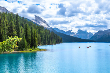 Tourists canoeing on maligne lake in jasper national park, alberta, canada