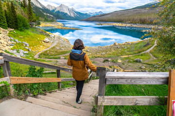 Tourist walking down wooden stairs at medicine lake in jasper national park