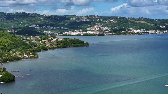 4k aerial video footage, right panning across landscape around Bay of Robert, a large bay on the Atlantic east coast of Martinique with many small islets, surrounded by green, hilly landscape