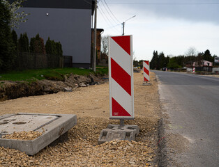Roadwork warning sign placed next to a street during reconstruction works. Concept of road safety, infrastructure repair and traffic management. Ideal for municipal projects, construction company mark