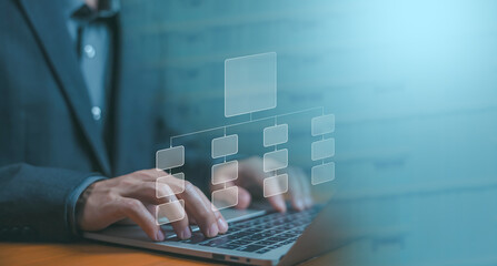 A businessman designs a digital project chart on a laptop. Concept of process management, workflow planning, and algorithm flow system. corporate structure, business flowchart automation