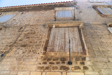 Stare zabytkowe kamienice i uliczki w mieście Trogir w Chorwacji z pięknymi oknami i okiennicami.  © Franciszek