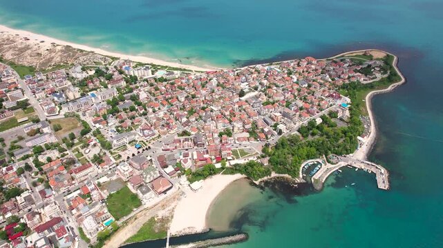 Aerial view of the town of Primorsko where the terracotta rooftops contrast with the turquoise waters of the Black Sea coastline, Primorsko, Burgas, Bulgaria.