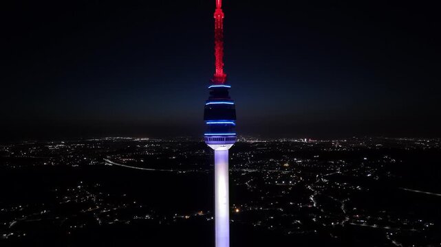 Aerial view of the illuminated Avala Tower piercing the night sky, standing tall above the sprawling cityscape, Belgrade, City of Belgrade, Serbia.