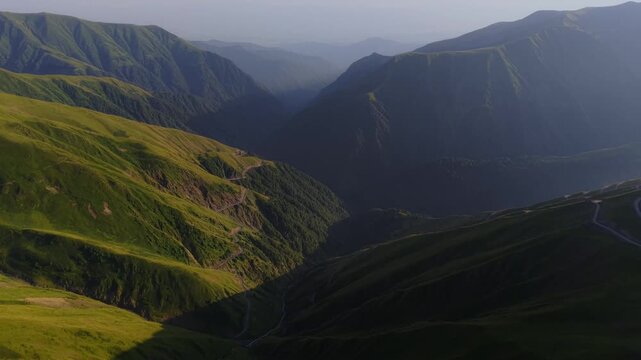 Aerial view of the Alazani Pass, where verdant mountains meet the hazy horizon in a stunning display of nature's grandeur, Chala, Tusheti, Georgia.