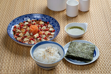 A platter of pickled sliced salmon in fish sauce, served with steaming rice and crispy seaweed
