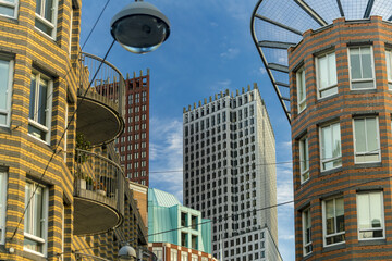 View of modern buildings with unique architecture and colorful brickwork reaching towards a vibrant blue sky, The Hague, South Holland, Netherlands.