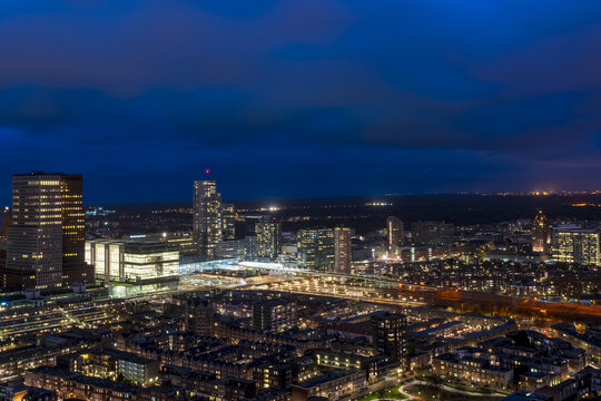 View of the city lights glowing against the dark sky, with towering buildings and illuminated streets creating a stunning urban panorama, The Hague, South Holland, Netherlands.