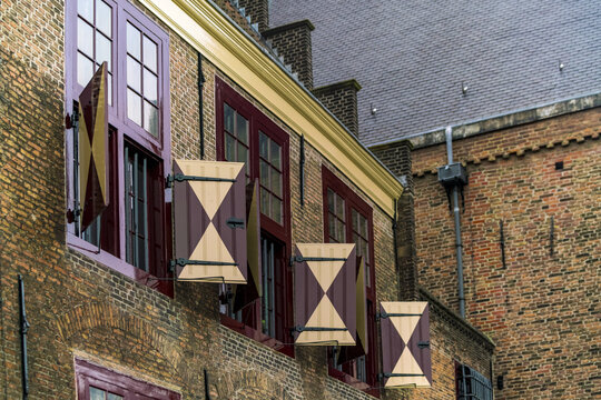 View of brick buildings with striking red-framed windows and unique diamond-patterned shutters create a captivating architectural display, The Hague, South Holland, Netherlands.