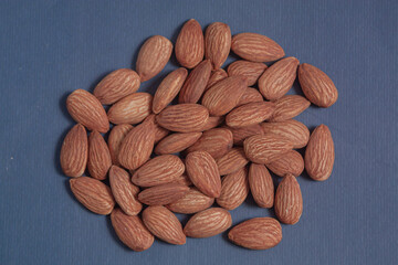 Almonds rest on a simple piece of paper, highlighting their natural texture in a clean minimal scene.