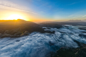 Aerial Sunrise Above the Clouds at Caminito del Rey, Guadalhorce Lake, and the Pine Forests of Andalusia, Spain