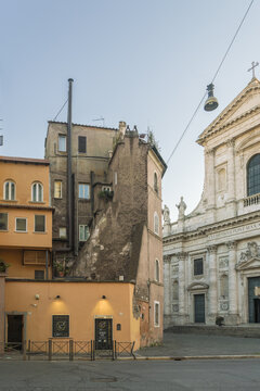 View of ancient buildings stand in stark contrast to the modern world in the heart of the Italian city, casting shadows on the empty square, Rome, Lazio, Italy.