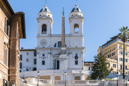View of the Trinit&agrave; dei Monti church and obelisk stand majestically above the Spanish Steps under a crisp blue sky, Rome, Lazio, Italy.