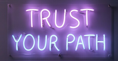 Fototapeta premium Bright purple neon sign displays positive message. Wall background provides contrast. Simple, modern aesthetic. Inspiring words illuminate space.