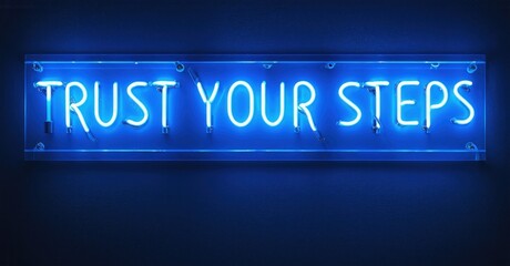Fototapeta premium Bright neon sign displays motivational phrase. Blue light glows against dark wall. Simple, inspiring message visible.