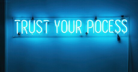 Fototapeta premium Bright blue neon sign displays positive message. Wall background provides contrast. Simple, motivational interior design element.
