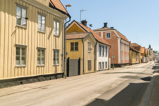 View of sun-drenched streets lined with colorful wooden houses, showcasing the unique architecture and charm of the town, Vastervik, Kalmar County, Sweden.