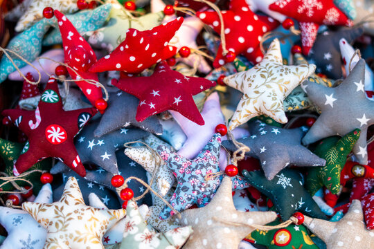Handmade fabric Christmas stars, colorful sewn holiday ornaments displayed at winter market stall