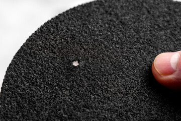 Hand holding water purification filter with fibrous texture and black rough surface