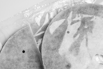 Two water filter cartridges packed in transparent plastic packs close up