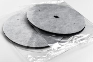 Packaged round industrial filtration discs in transparent plastic. Clean water system components. Household maintenance supplies
