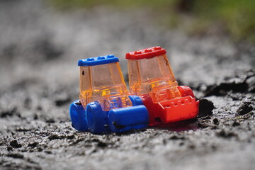 Two colorful toy tractors on a textured ground, vibrant and playful.