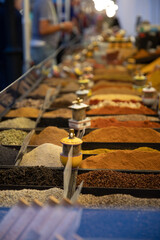 contenitori pieni di vari tipi di spezie, esposti in vetrina in pubblico durante un evento